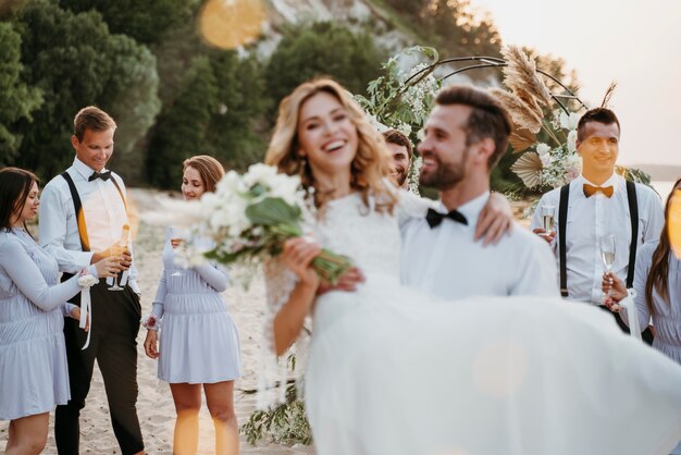 Jeunes mariés ayant leur mariage avec des invités sur une plage