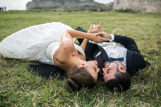 Jeunes mariés dans l&#39;amour couché sur l&#39;herbe