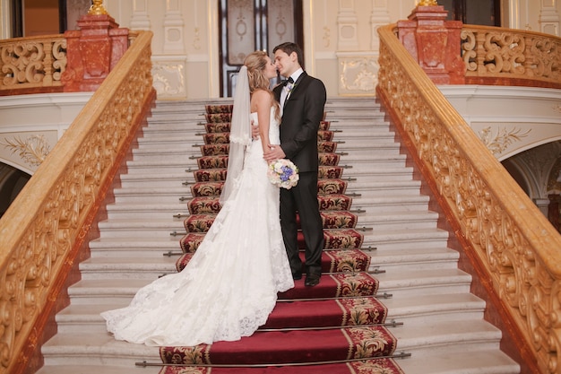 Photo gratuite jeunes mariés dans un baiser escalier