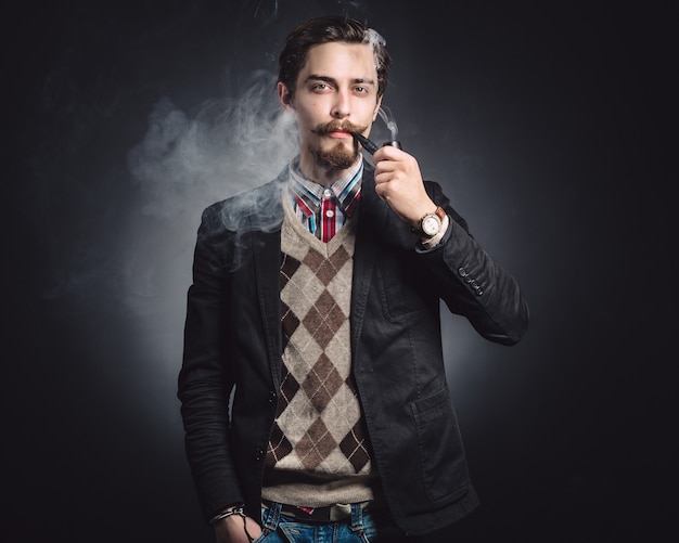 Photo gratuite jeunes messieurs fume une pipe