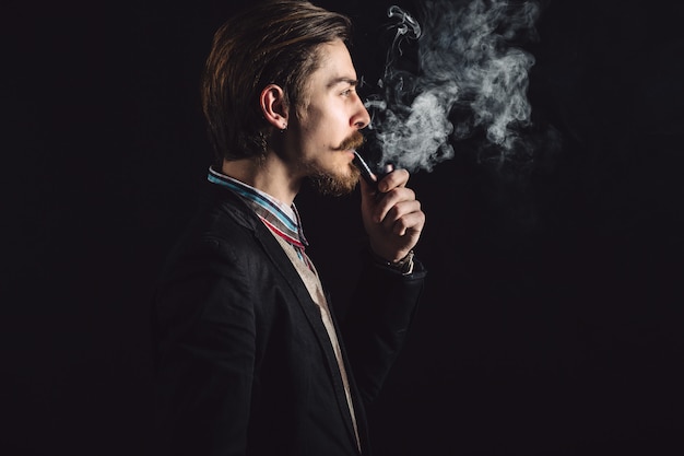 Photo gratuite jeunes messieurs fume une pipe