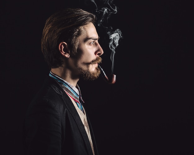 Photo gratuite jeunes messieurs fume une pipe