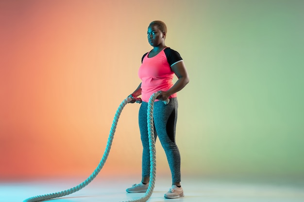 Jeunes modèles féminins de taille plus afro-américains formation sur mur dégradé