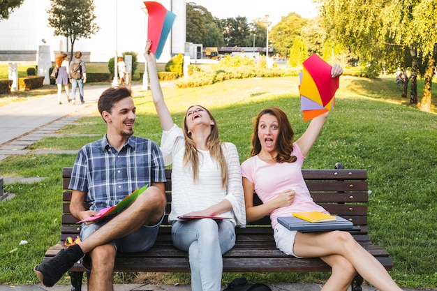 Les jeunes avec des papiers lumineux sur le banc