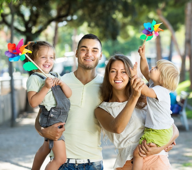 Jeunes parents avec des enfants jouant aux moulins à vent