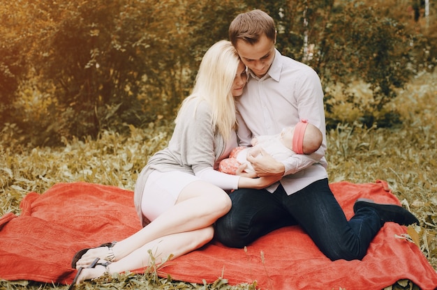 Les jeunes parents étreignant leur bébé dans le parc