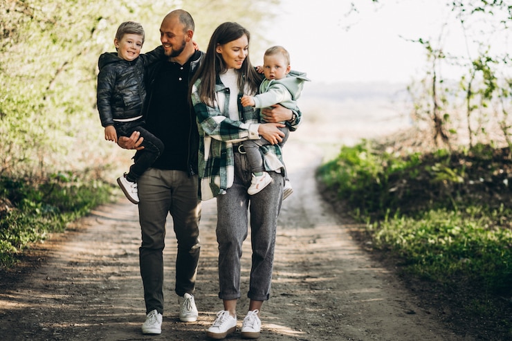 Photo gratuit jeunes parents avec leurs enfants dans la forêt