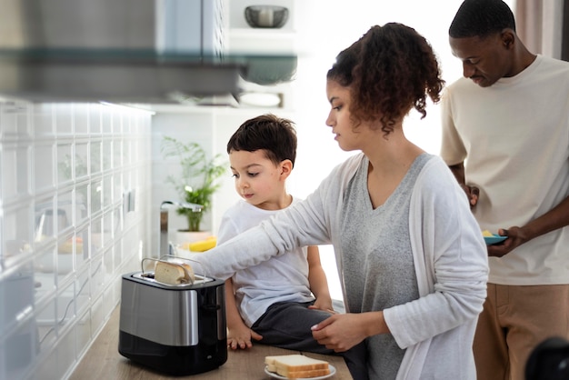 Jeunes parents préparant des toasts avec son fils