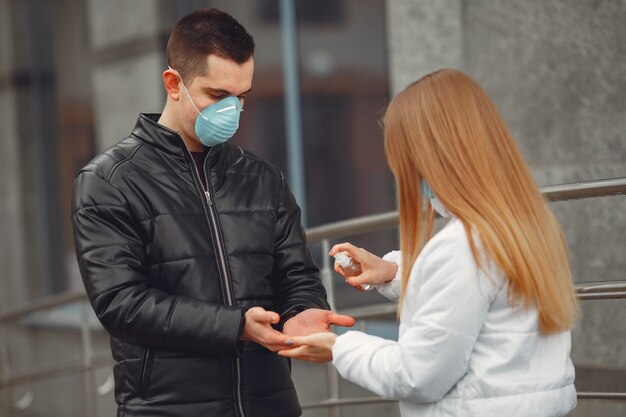 Les jeunes portant des masques de protection pulvérisent un désinfectant pour les mains