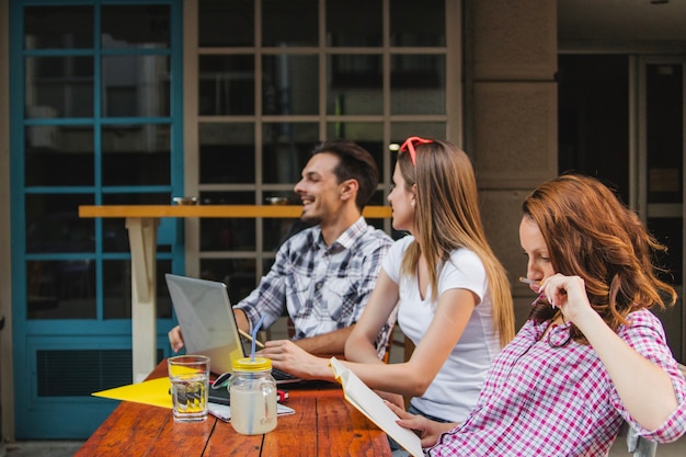 Les jeunes posent au bureau dans un café