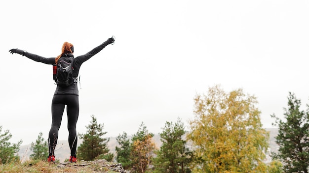 Jogger sportif féminin qui s'étend de loin par derrière