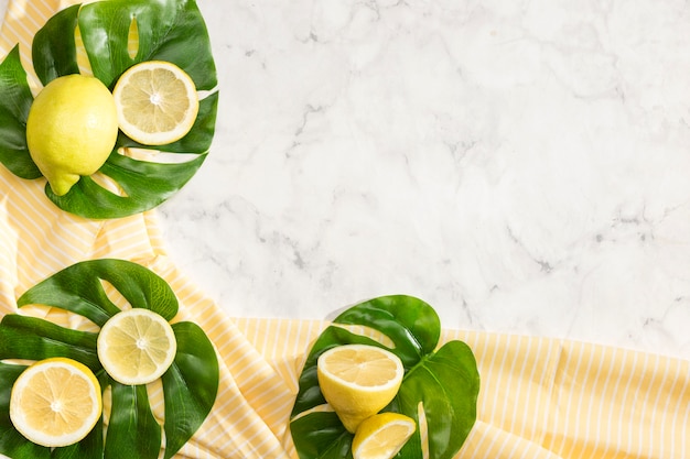 Joli arrangement de citrons sur des feuilles de monstera