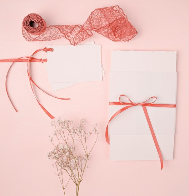 Joli arrangement à poser pour les invitations de mariage sur fond rose