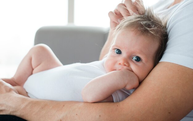 Joli bébé sur les bras du père à la maison