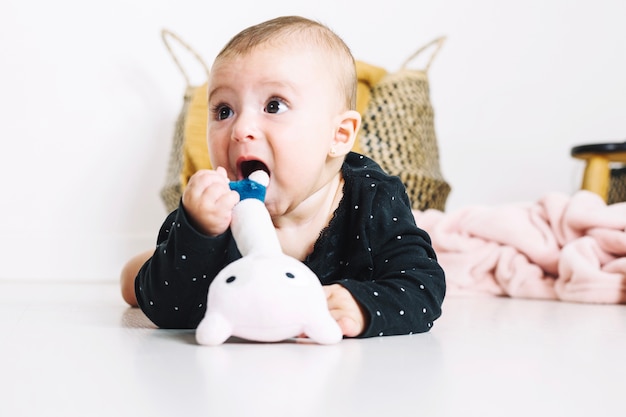 Joli bébé essayant de mordre le jouet