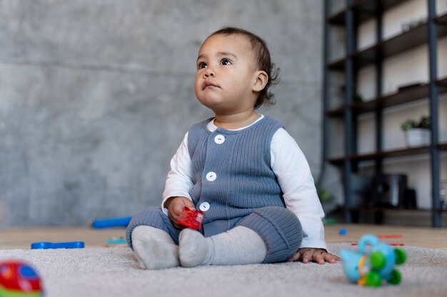 Joli bébé jouant sur le sol avec un jouet