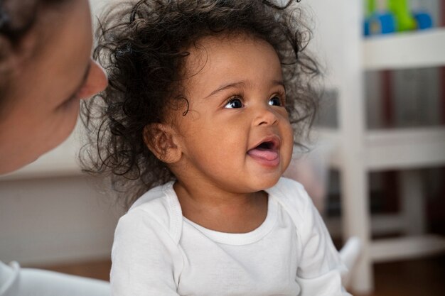 Joli bébé noir à la maison avec ses parents