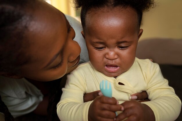 Joli bébé noir à la maison avec ses parents