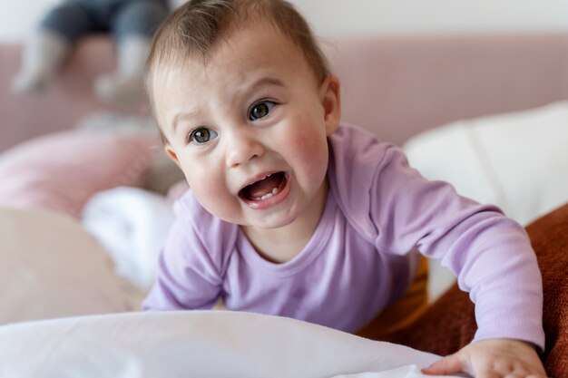 Joli bébé rampant sur le lit et pleurant