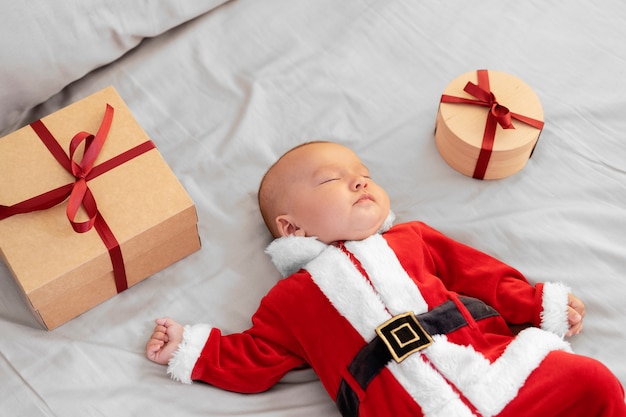 Photo gratuite joli bébé vêtu de vêtements de père noël