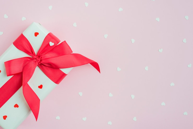 Photo gratuit joli cadeau près des coeurs en rose