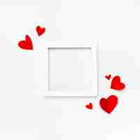 Photo gratuite joli cadre carré blanc avec fond pour texte sur fond blanc décoré de coeurs en papier fait main