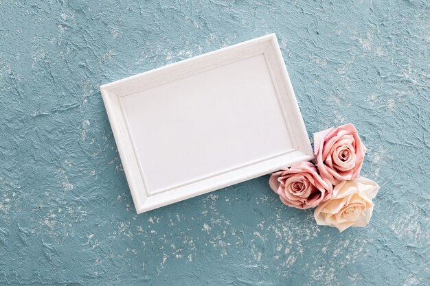 Joli cadre de mariage avec des roses sur fond texturé bleu