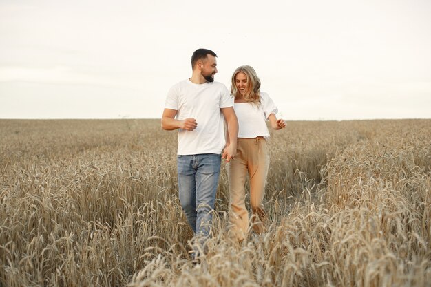 Joli couple dans un champ. Dame dans un chemisier blanc. Guy en chemise blanche