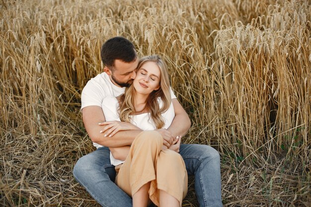 Joli couple dans un champ. Dame dans un chemisier blanc. Guy en chemise blanche