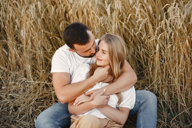 Joli couple dans un champ. Dame dans un chemisier blanc. Guy en chemise blanche