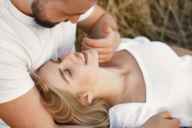 Joli couple dans un champ. Dame dans un chemisier blanc. Guy en chemise blanche