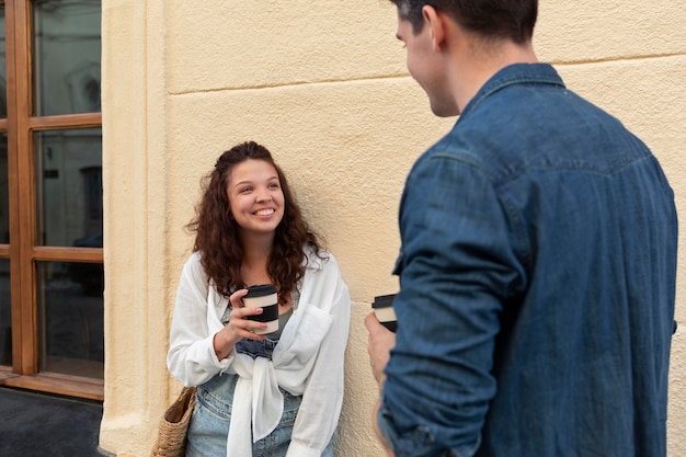 Joli couple dégustant une tasse de café à l'extérieur