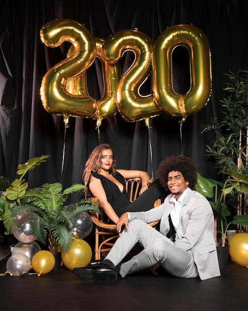 Photo gratuite joli couple entouré de ballons avec 2020 nouvel an