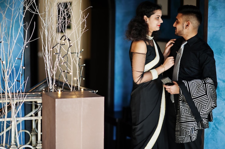 Photo gratuit joli couple indien amoureux portant un sari et un costume élégant posé au restaurant
