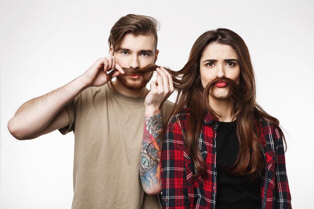 Joli couple jouant avec les cheveux, faisant des grimaces idiotes, s'amusant.