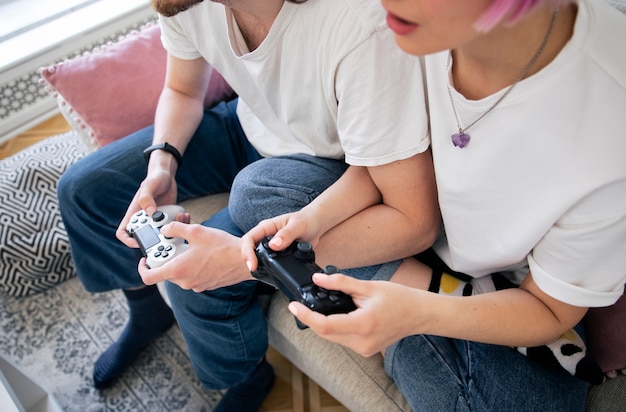 Joli couple jouant à des jeux vidéo sur le canapé