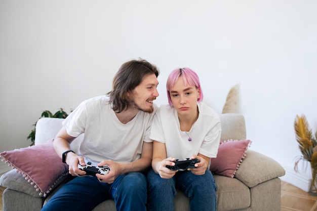Joli couple jouant à des jeux vidéo à l'intérieur