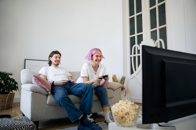 Photo gratuite joli couple jouant à des jeux vidéo à la maison