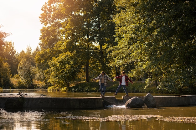 Photo gratuite joli couple marchant dans la nature long shot