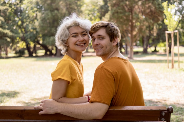 Joli couple posant sur un banc dans le parc
