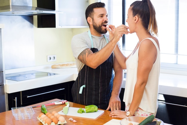 Joli couple s&#39;alimentant dans la cuisine