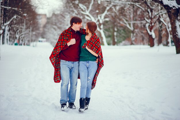 Joli couple s&#39;amuser dans un parc d&#39;hiver