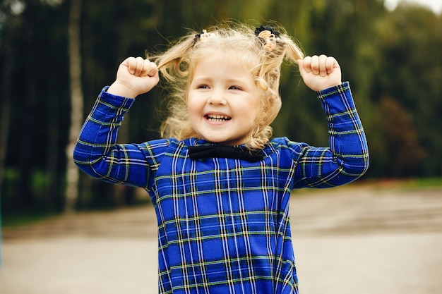 Photo gratuite joli enfant dans un parc jouant sur l'herbe