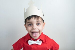 Photo gratuite joli garçon avec des vêtements classiques avec une couronne en papier