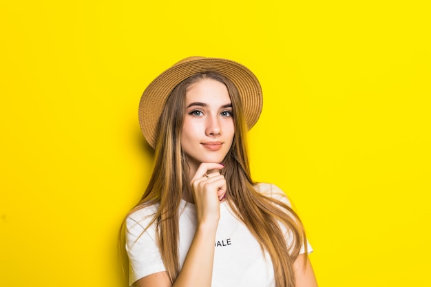 Joli modèle en t-shirt blanc et chapeau sur fond orange avec grimace