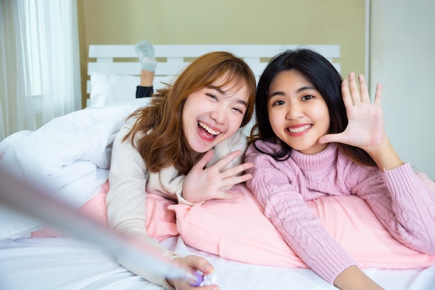 Jolie adolescente selfie sur le lit à la maison