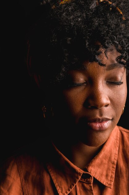 Jolie africaine jeune femme frisée sur fond noir