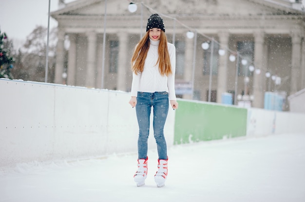Photo gratuite jolie et belle fille dans un pull blanc dans une ville d'hiver