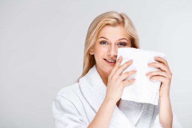 Jolie blonde femme en peignoir avec serviette de bain