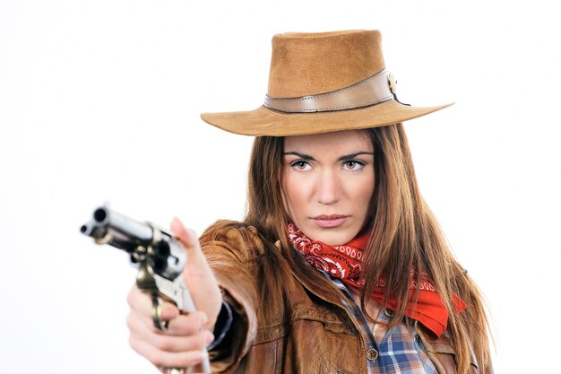 Jolie cowgirl avec pistolet sur fond blanc